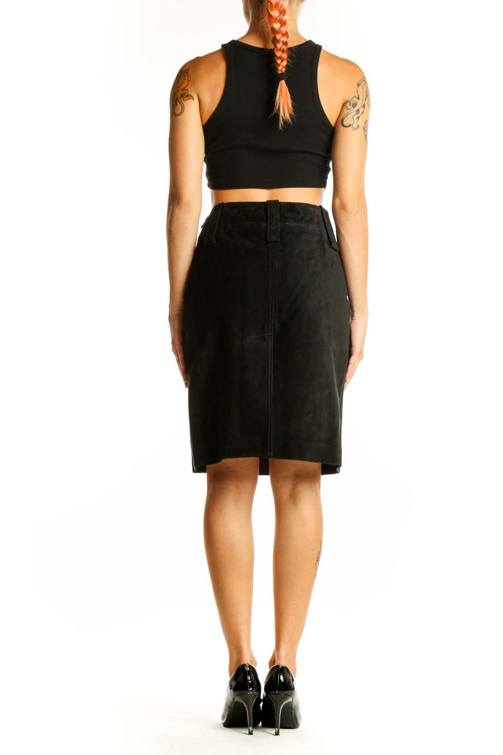 Side view of model wearing DKNY black leather pencil skirt with black crop top