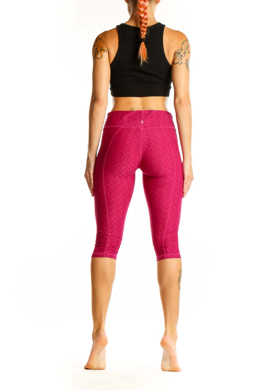 Side view of woman wearing pink textured capri leggings and black crop top
