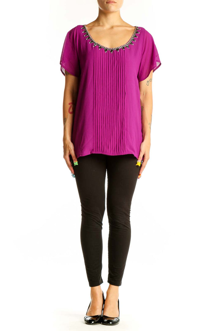 Front view of magenta pleated blouse with embellished neckline
