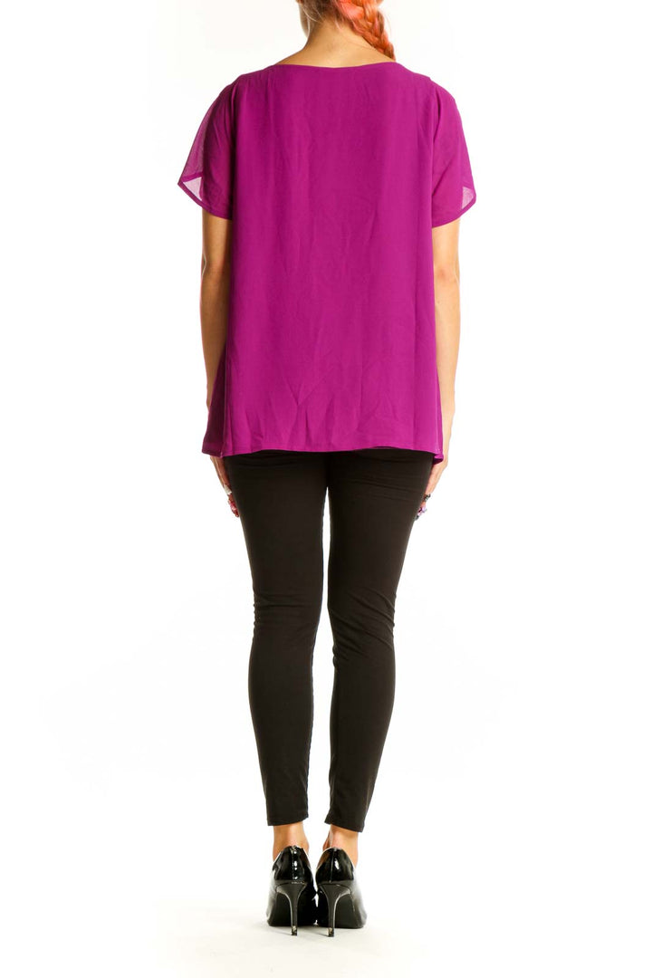 Side view of magenta pleated blouse showing drape and fit
