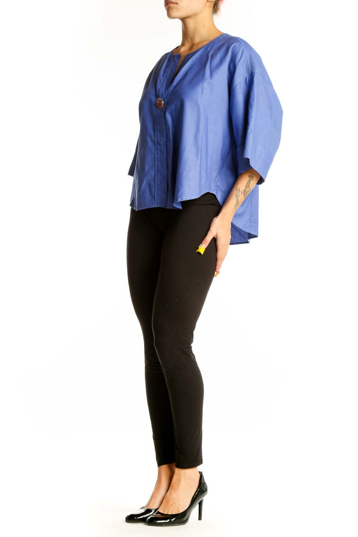 Front view of blue cotton kimono-style top with oversized sleeves and button closure