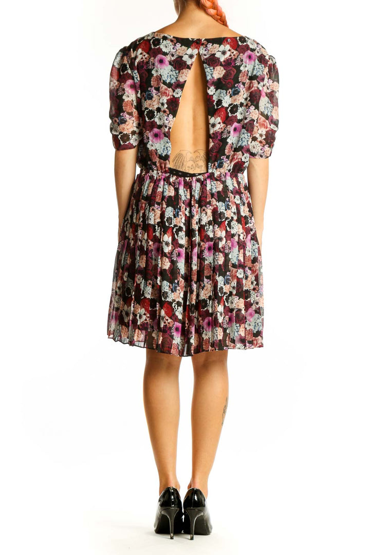 Side view of Pins and Needles burgundy floral dress showing puff sleeves and pleated skirt