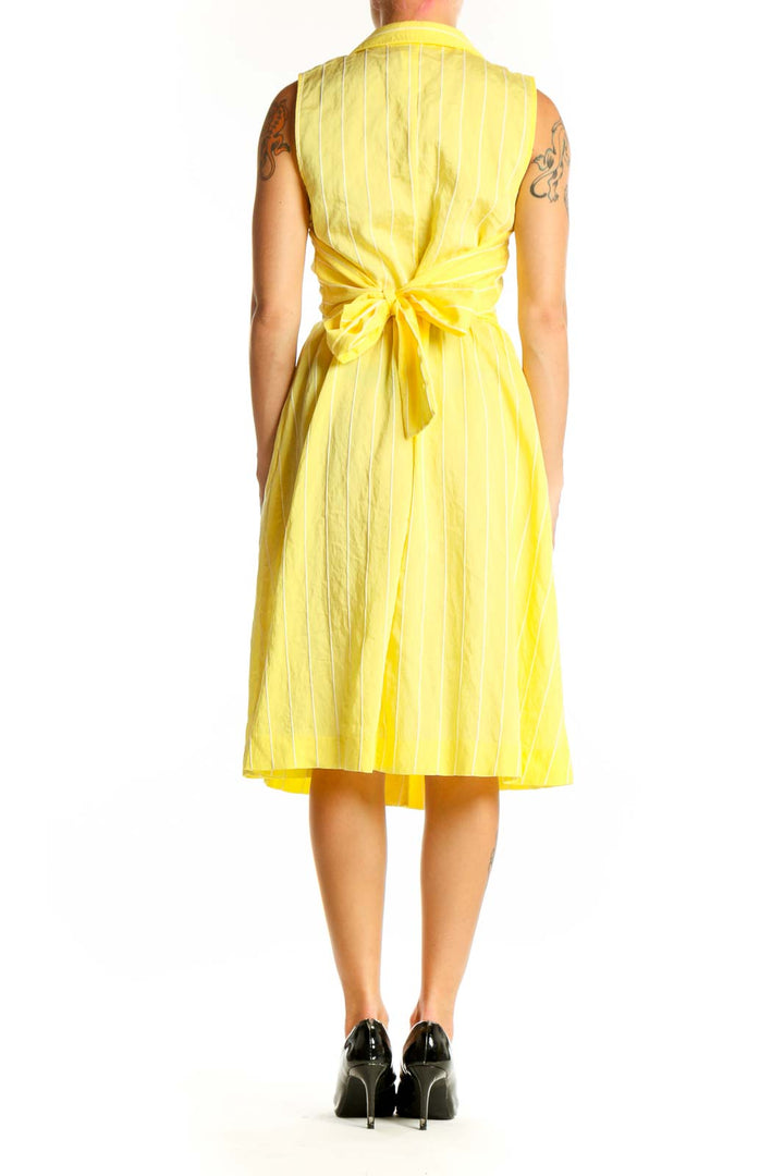 Side view of yellow striped sleeveless DKNY shirt dress showing pleated skirt