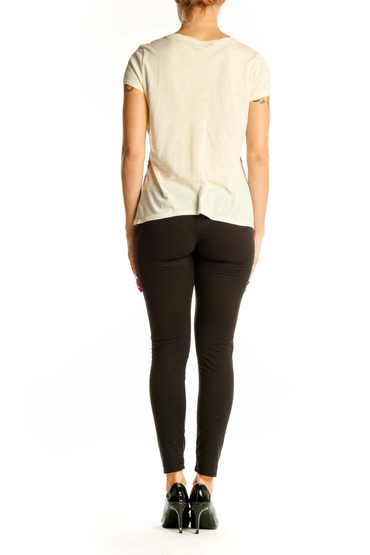 Side view of model wearing Tahari beige cotton top with black pants