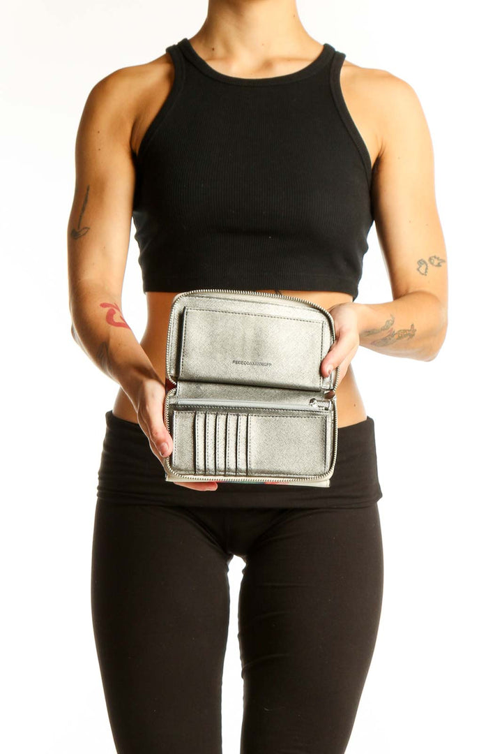 Rebecca Minkoff multicolor tie-dye envelope clutch held by model in black outfit