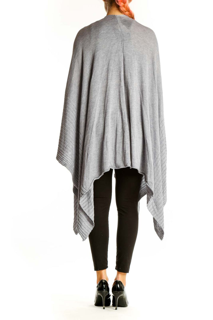 Back view of gray oversized knit poncho showing drape and length