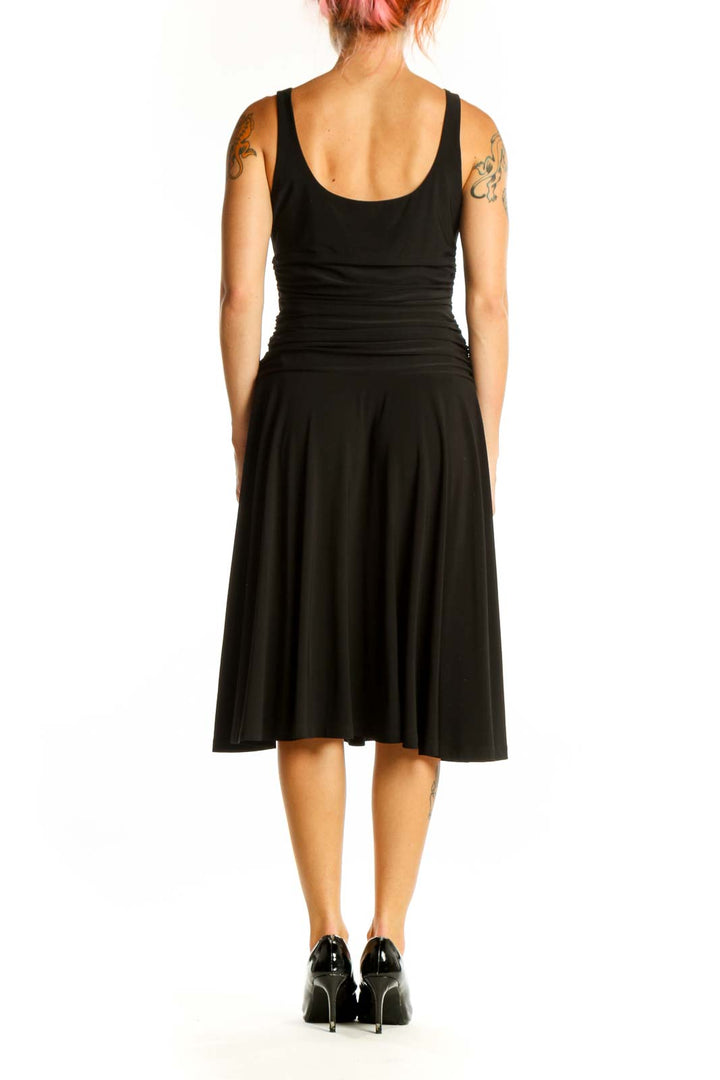 Side view of black A-line cocktail dress showing sleeveless design