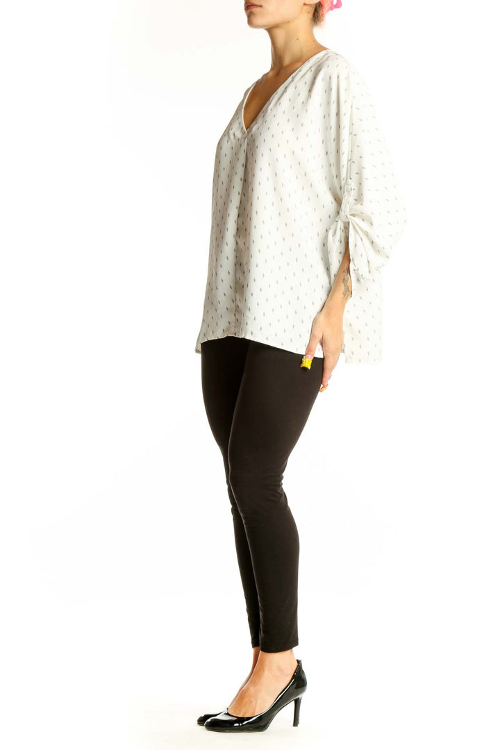 Front view of Vince Camuto white dotted V-neck blouse with tie sleeves