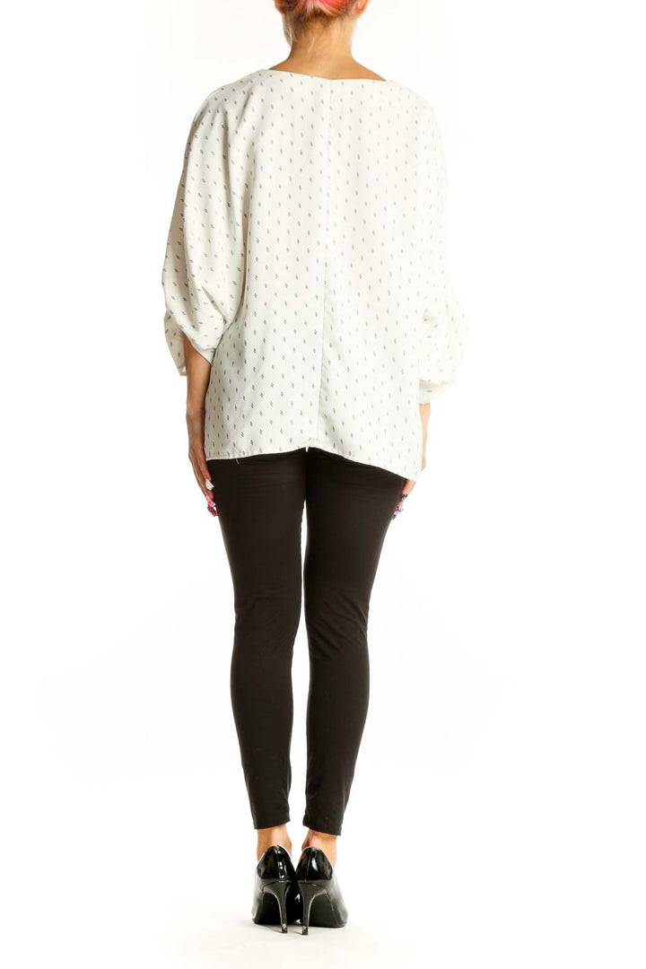 Side view of Vince Camuto white dotted V-neck blouse showing tie sleeve detail