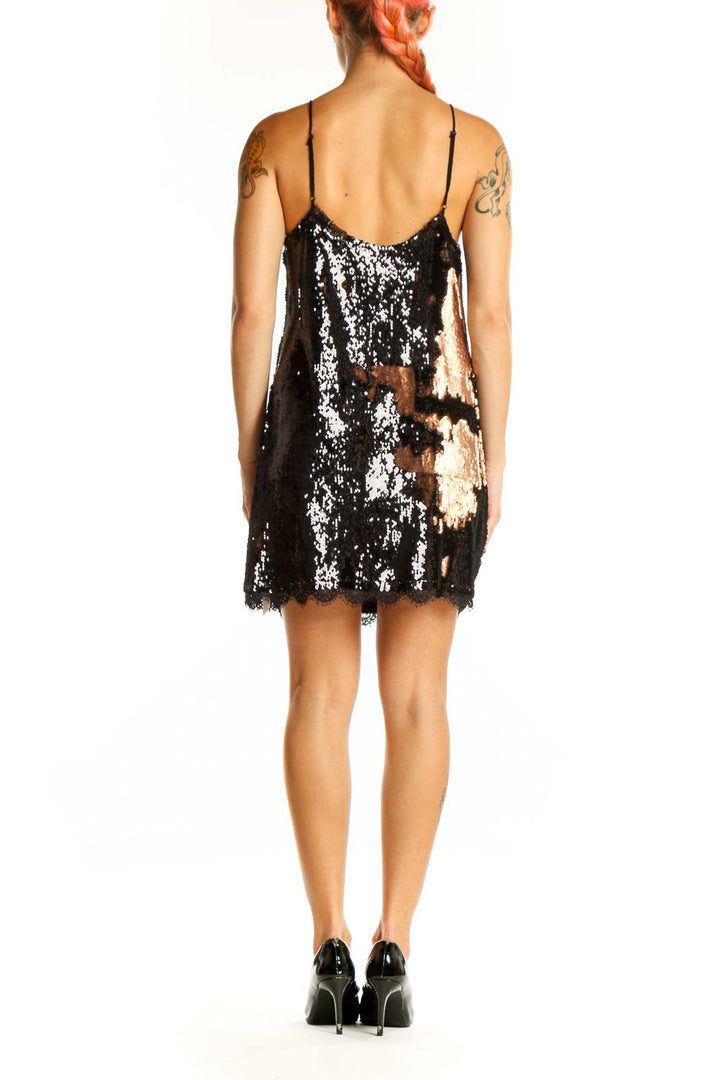Side view of black sequin slip dress showing spaghetti straps and mini length