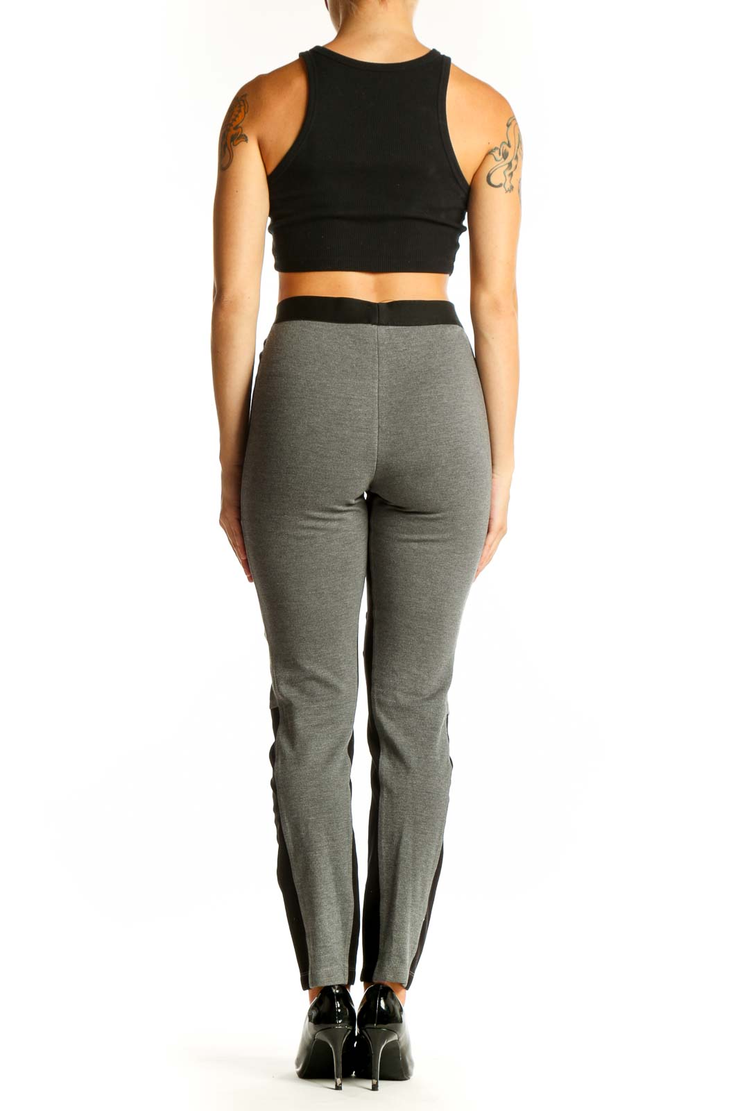 Side view of model wearing BCBG MaxAzria gray and black color block leggings with black crop top