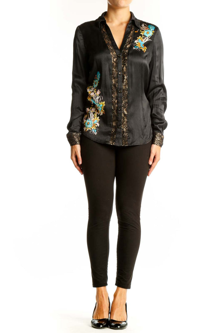 Front view of black silk Cache blouse with turquoise and gold floral embroidery