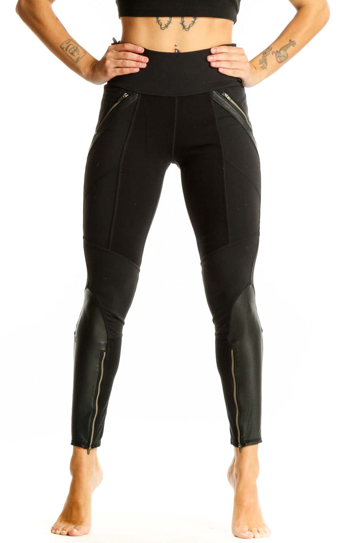 Front view of black Athleta athletic leggings with zipper pockets