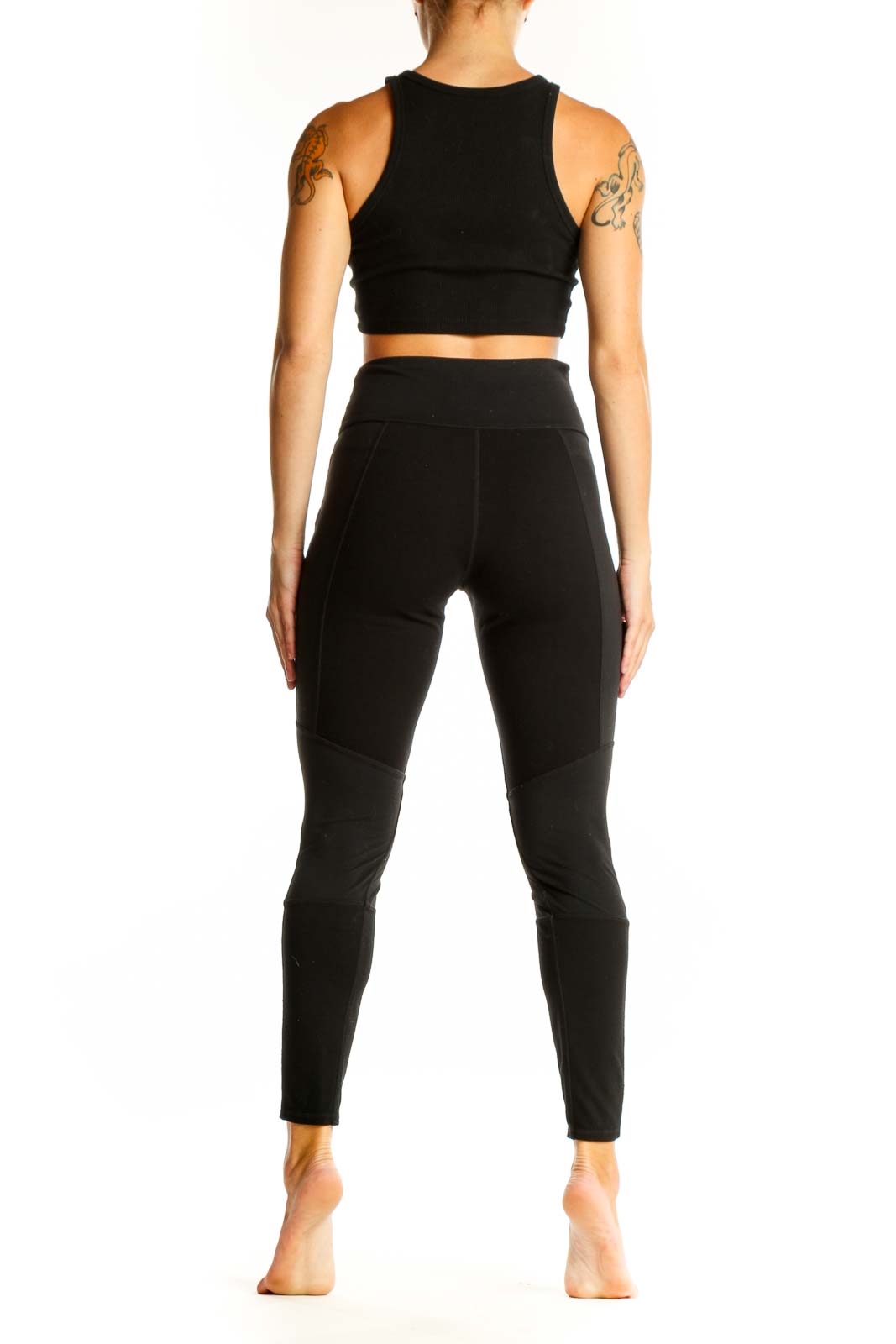 Side view of black Athleta leggings showing faux leather ankle details
