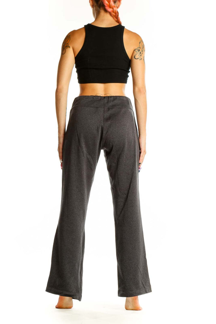 Side view of woman wearing gray The North Face lounge pants and black crop top