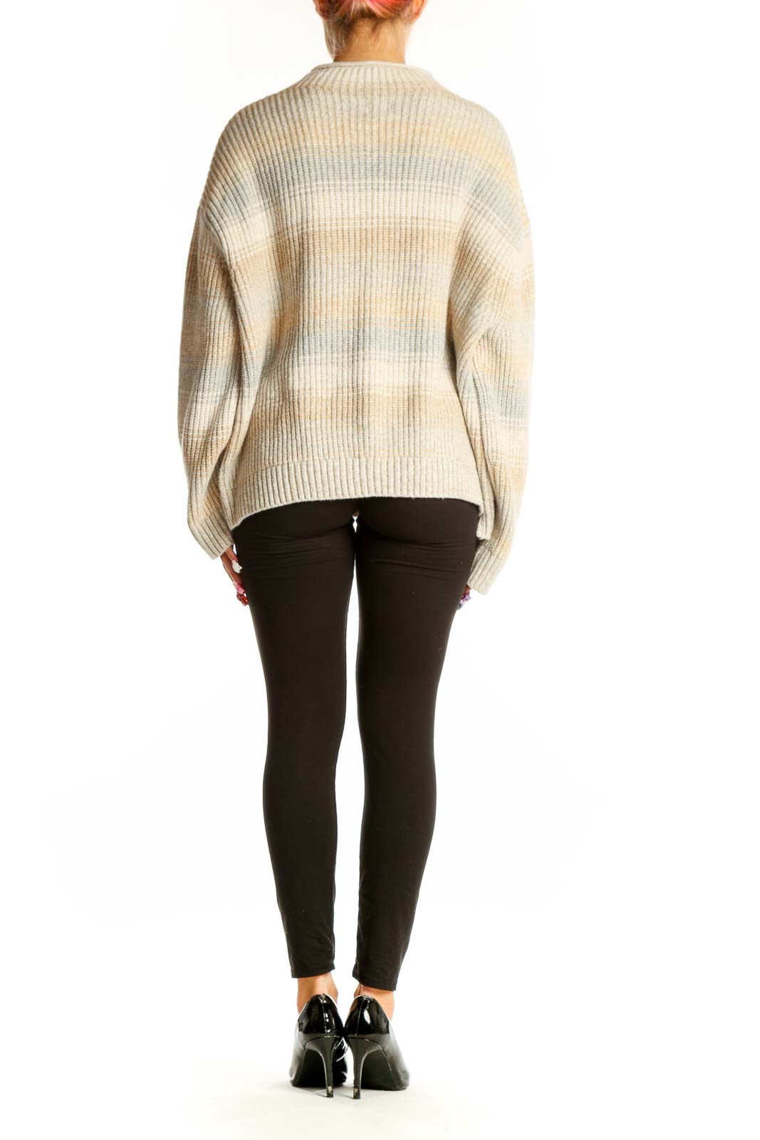 Side view of model wearing Gap beige striped oversized knit sweater with black pants