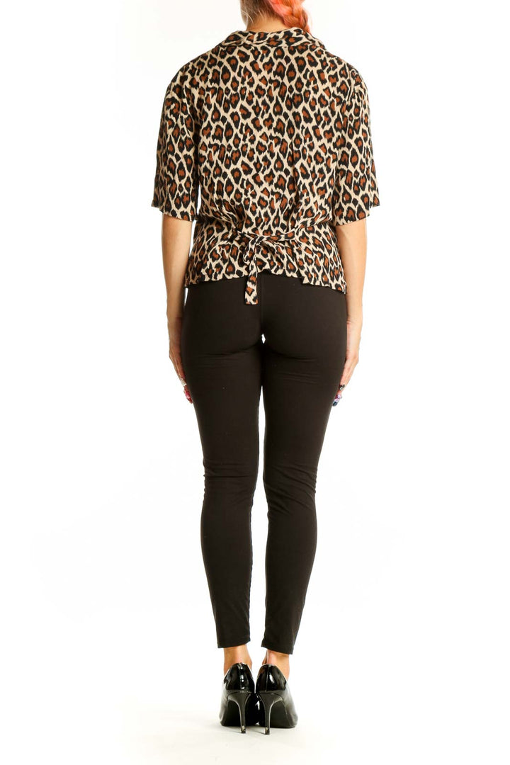 Side view of model wearing Croft & Barrow leopard print blouse with black pants