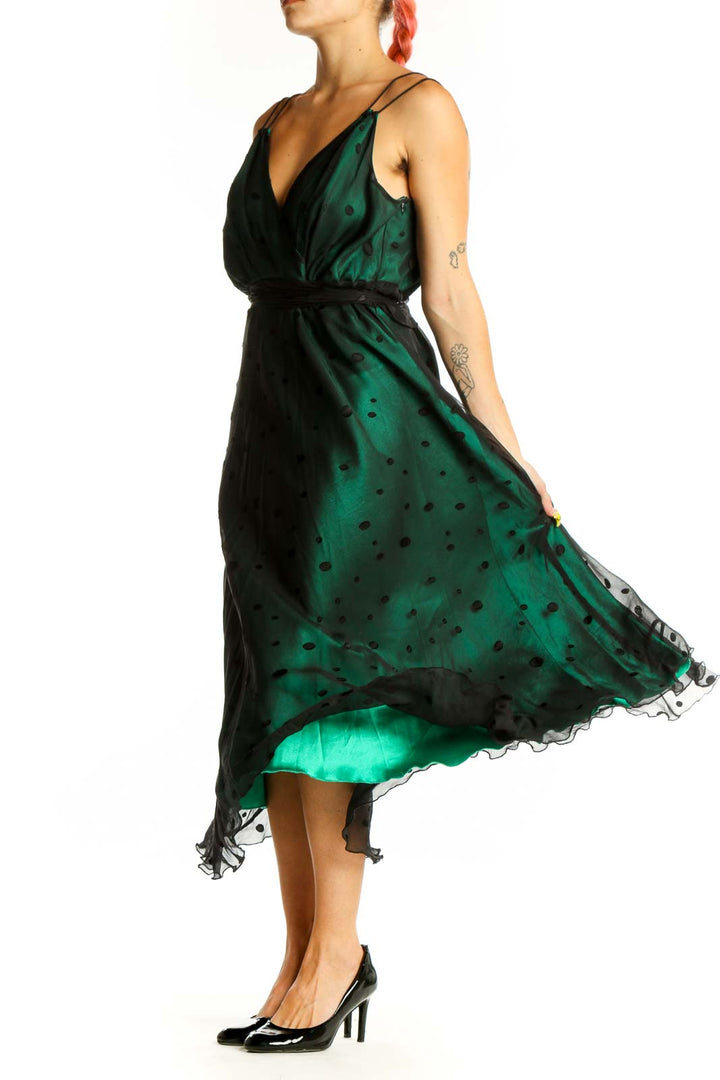 Front view of emerald green polka dot midi dress with wrap-style bodice and black waistband