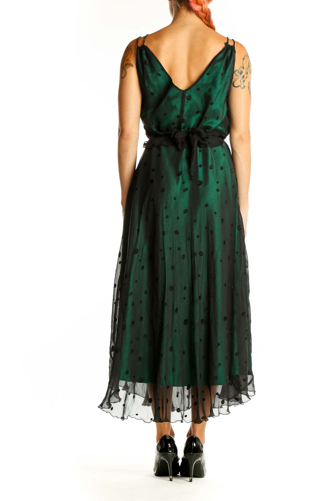 Side view of emerald green polka dot midi dress showing flowing skirt and high-low hemline