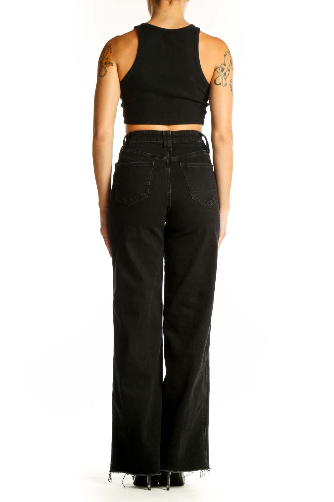 Side view of model wearing black wide-leg denim jeans with crop top