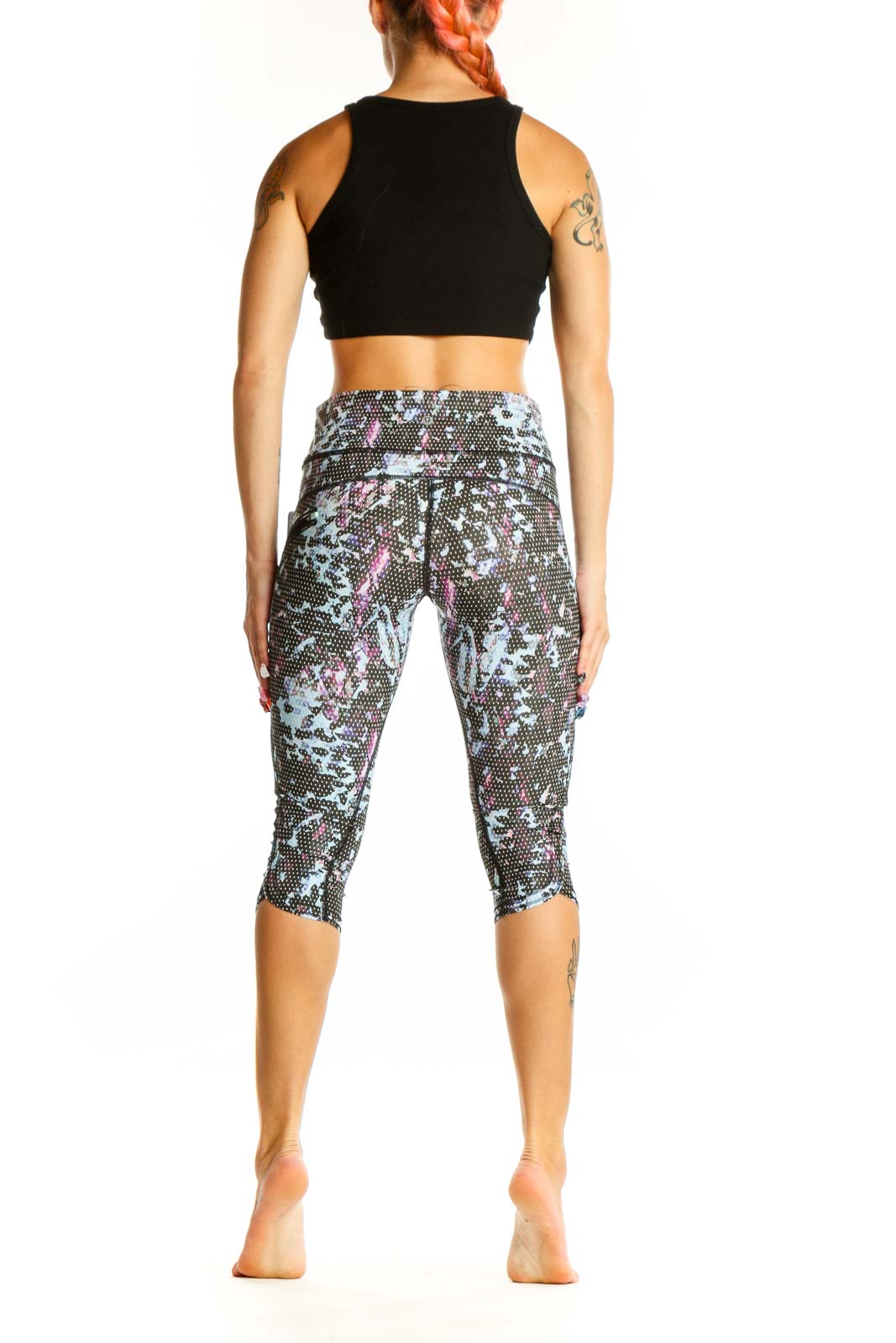 Side view of Lululemon blue floral print capri leggings with black crop top