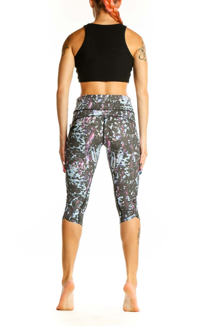 Side view of Lululemon blue floral print capri leggings with black crop top