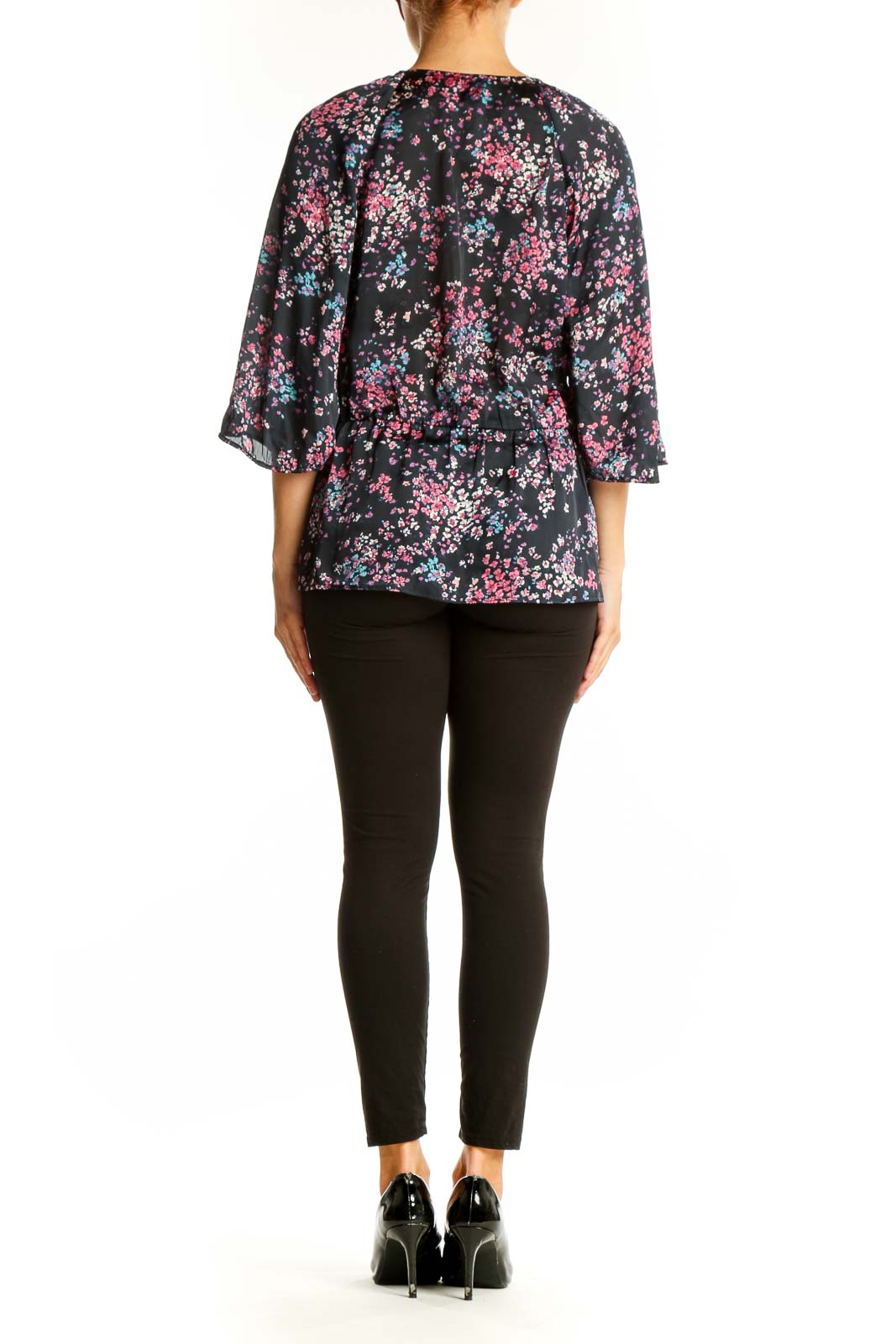 Side view of model wearing Banana Republic black floral print blouse with black pants