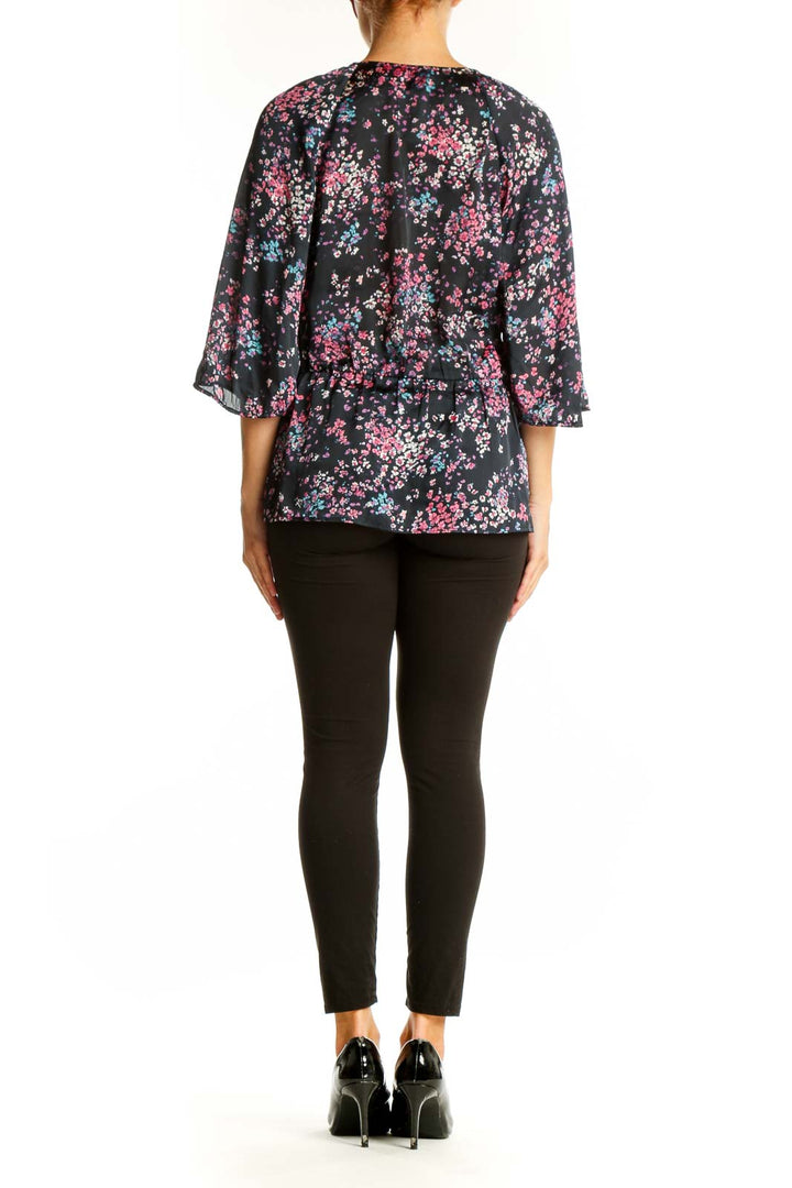 Side view of model wearing Banana Republic black floral print blouse with black pants