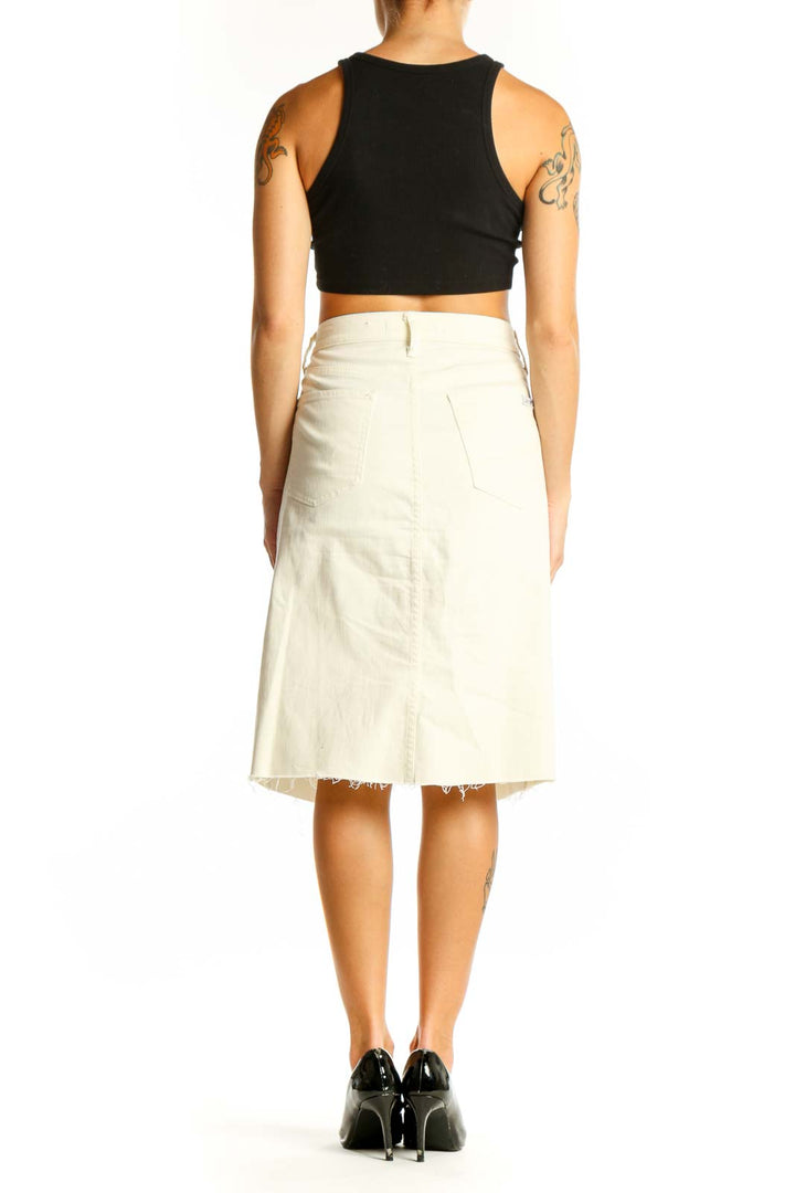 Side view of model wearing Joe's cream denim midi skirt with black top