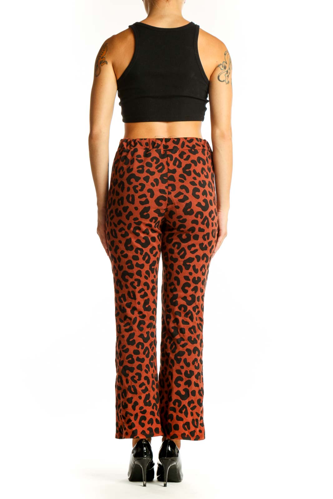 Side view of model wearing rust leopard print pants with black top