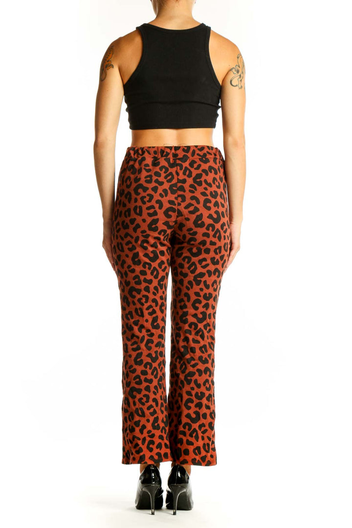 Side view of model wearing rust leopard print pants with black top