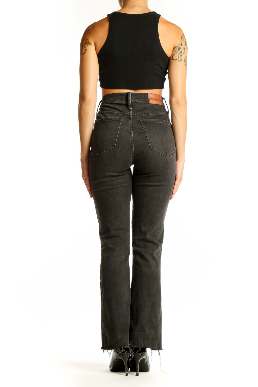 Side view of model wearing Madewell charcoal gray high-waisted flared jeans with black crop top