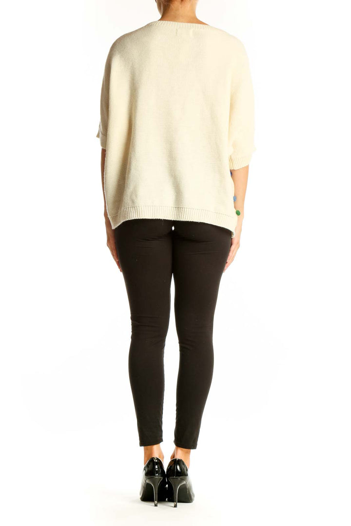 Side view of PepaLoves cream knit sweater showing colorful polka dot pattern
