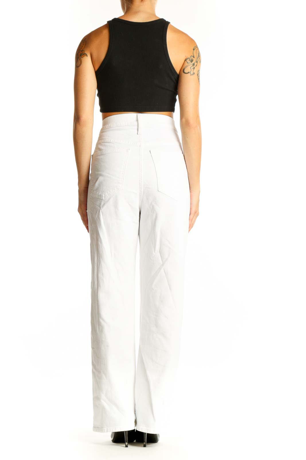 Side view of model wearing white high-waisted straight-leg jeans from J.Crew with black crop top