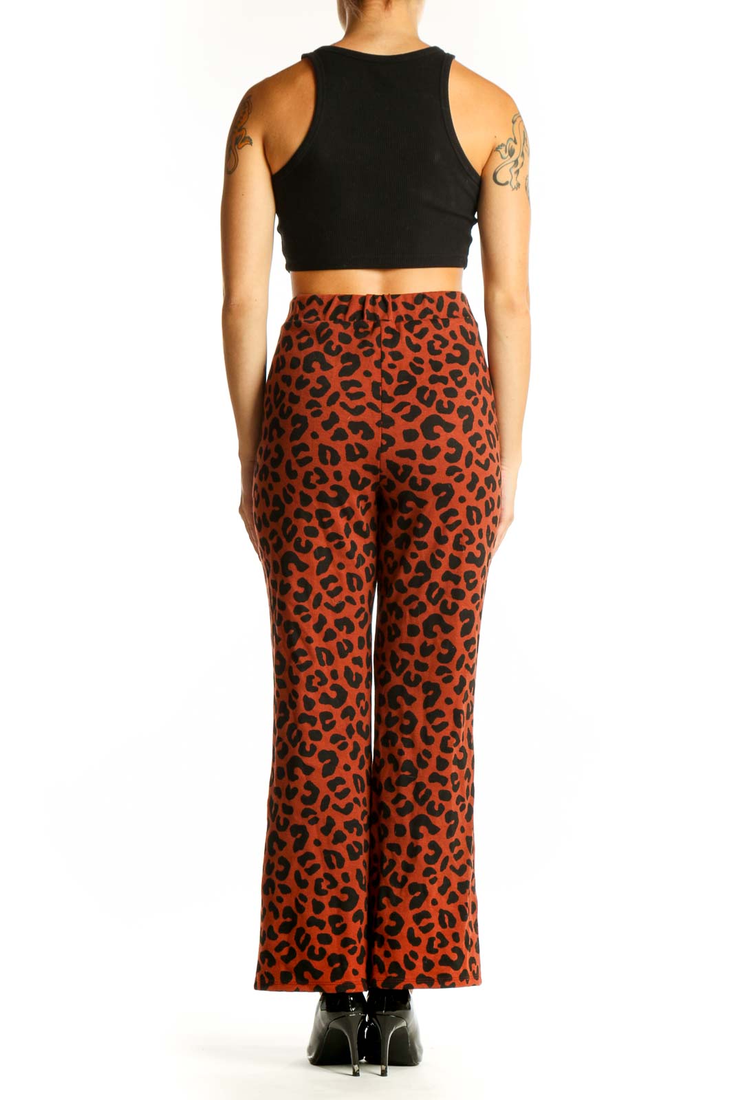 Side view of model wearing rust leopard print wide-leg pants with black crop top