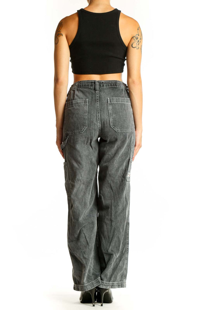 Side view of model wearing BDG gray washed cotton cargo jeans with black crop top