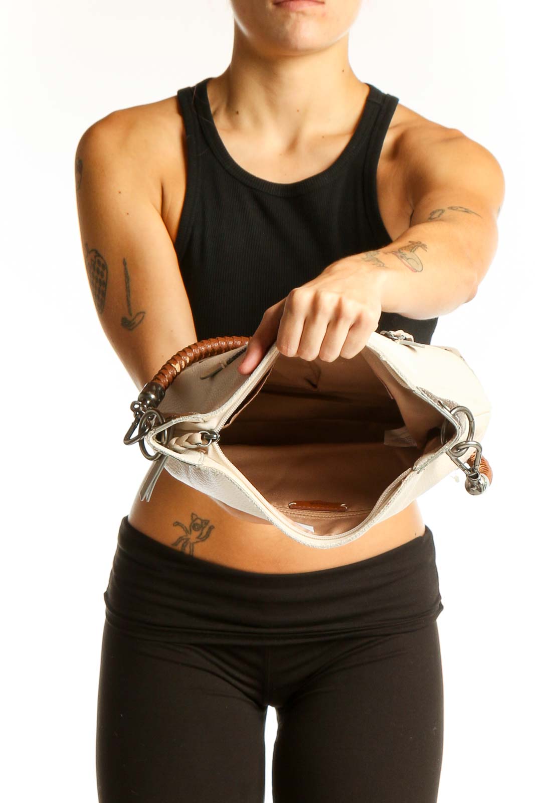 Side view of The SAK cream leather shoulder bag worn by model