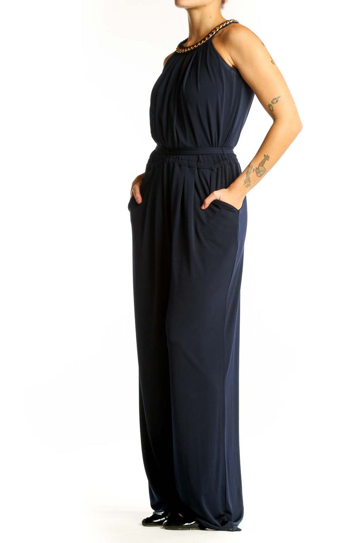 Front view of Vince Camuto navy jumpsuit with gold chain halter neck