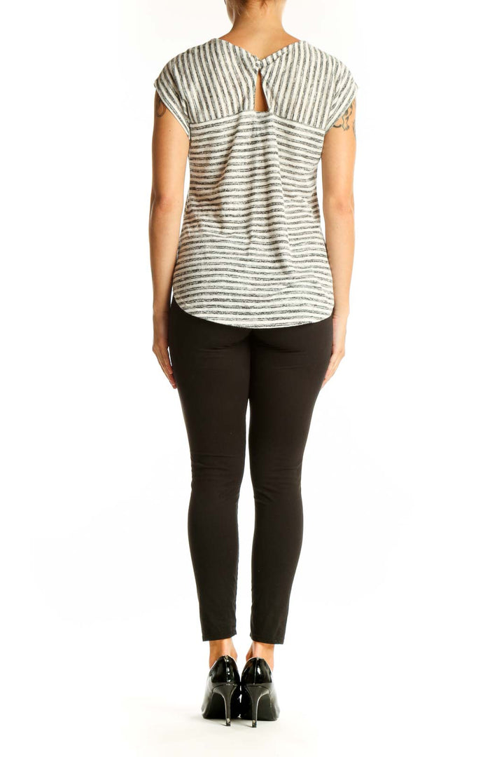 Side view of Bobeau Gray Striped Cap Sleeve Top paired with black pants