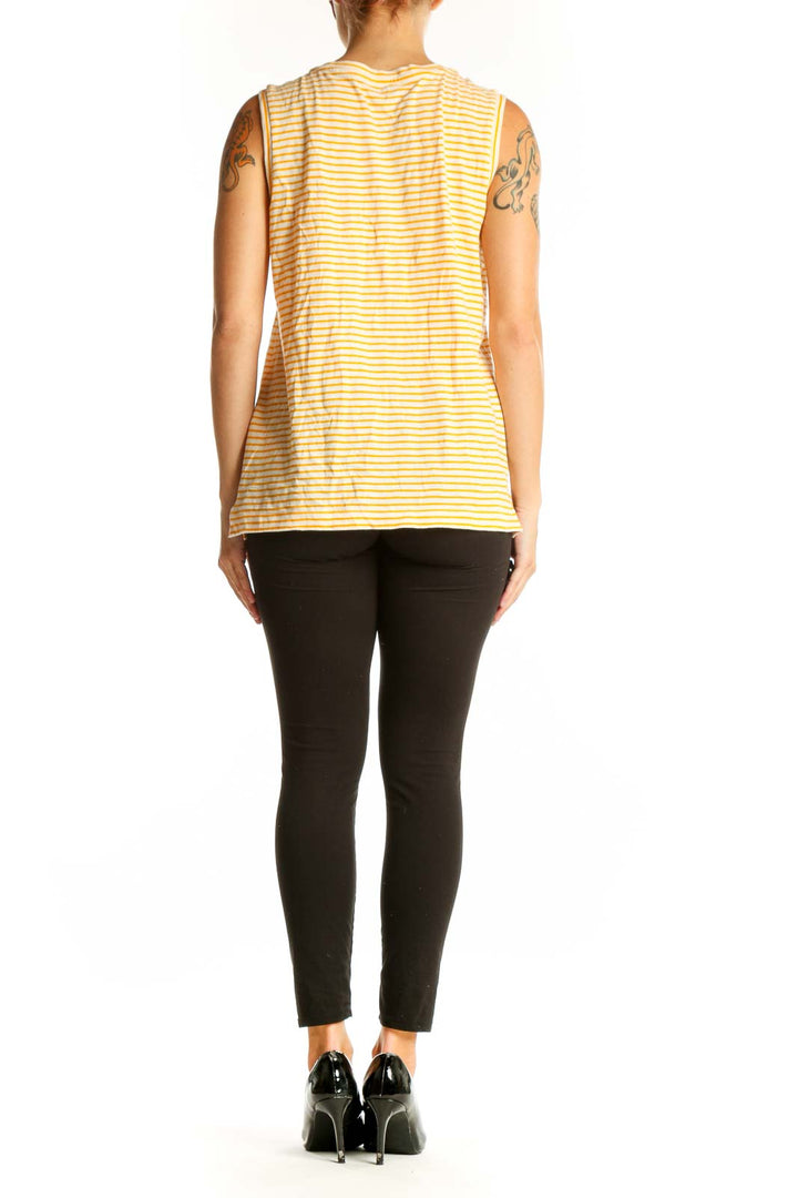 Side view of model wearing Madewell yellow and white striped sleeveless cotton top with black pants