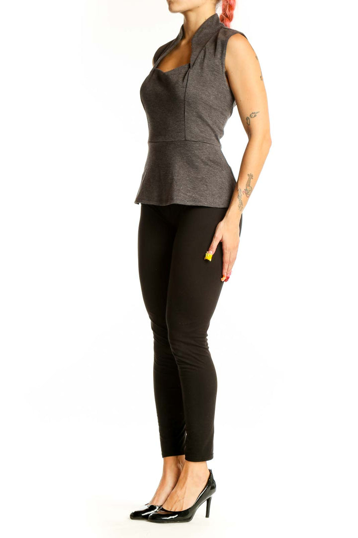 Front view of Eva Franco gray sleeveless peplum top with high collar