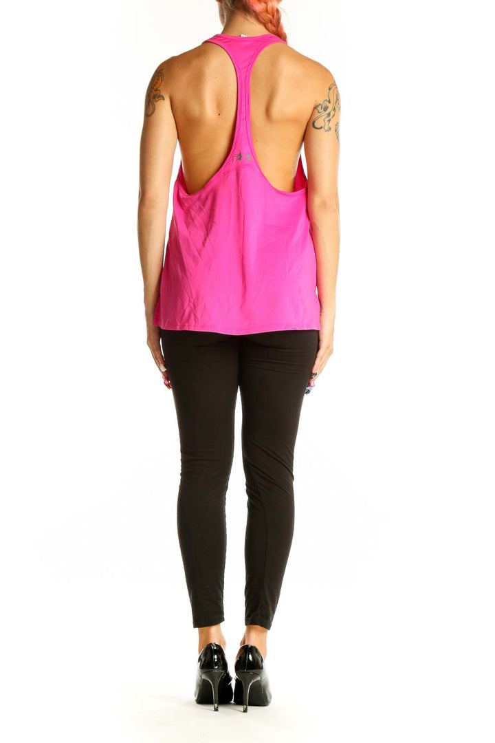 Side view of woman wearing pink HeatGear racerback tank top with black leggings
