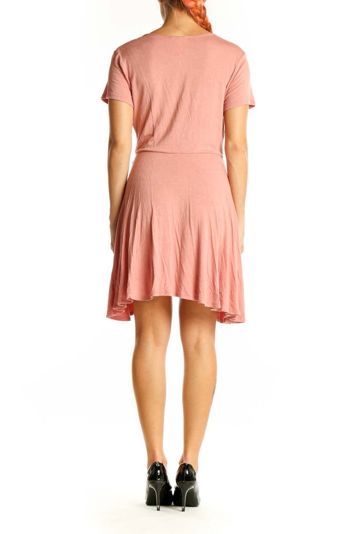 Side view of pink Rolla Coster wrap-style short sleeve top on model