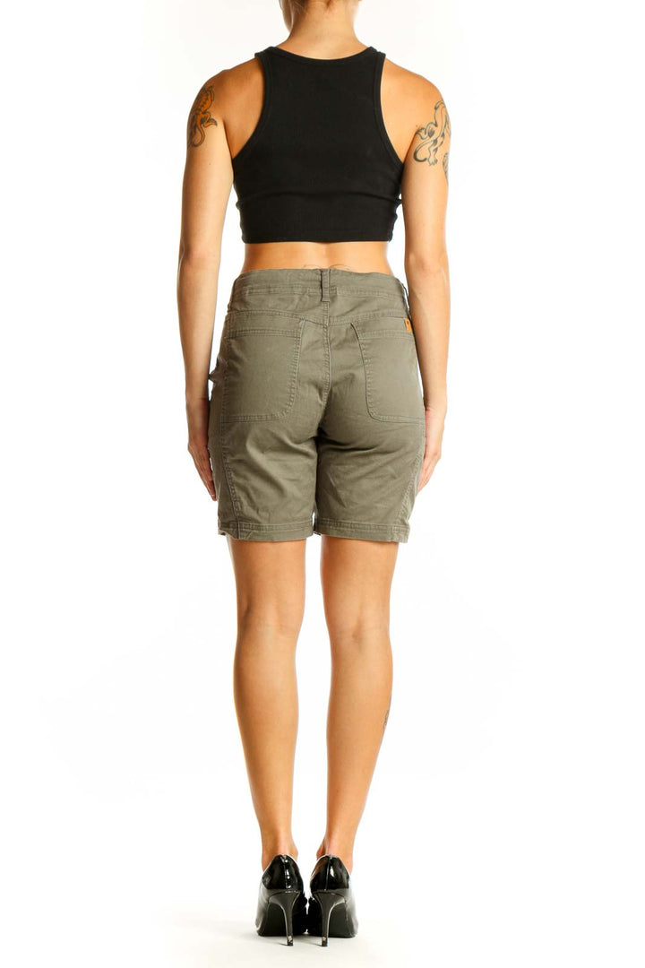 Side view of olive green Tentree 10 chino shorts on model with black crop top