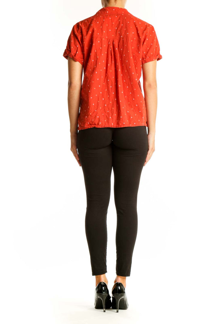 Side view of model wearing Madewell red polka dot shirt with black pants