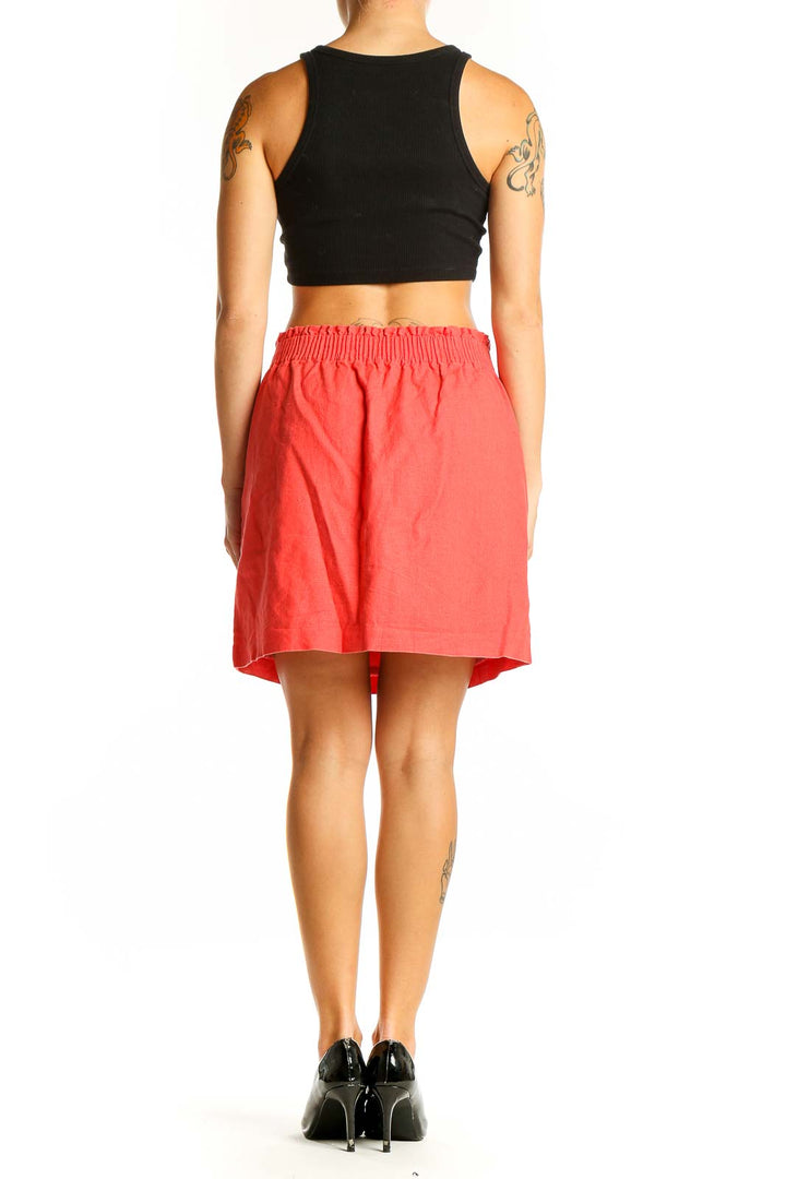 Side view of coral J.Crew mini skirt with visible pocket