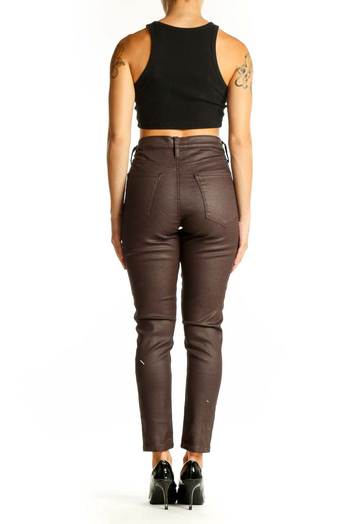 Side view of Banana Republic brown coated skinny jeans on model with black crop top