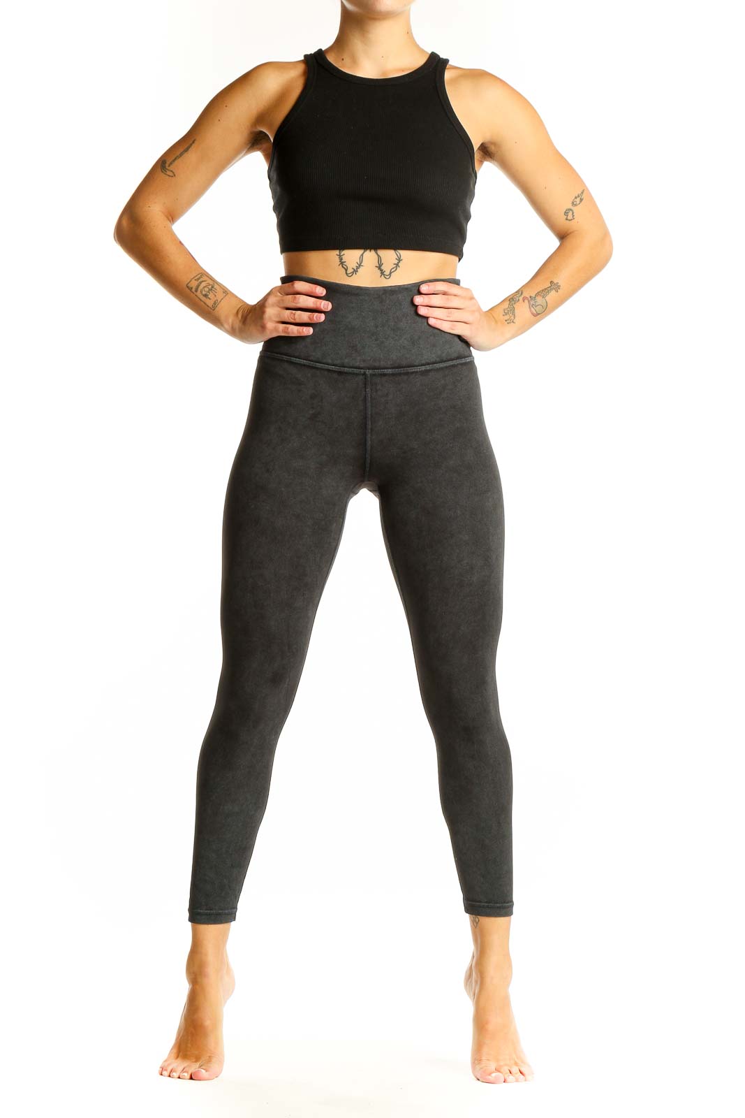 Front view of Athleta black crop top and charcoal gray high-waisted leggings activewear set
