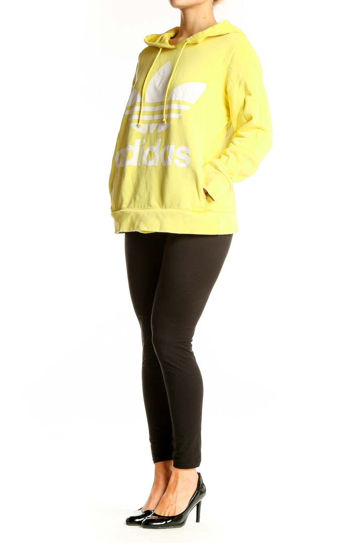 Front view of yellow Adidas hoodie with white Trefoil logo