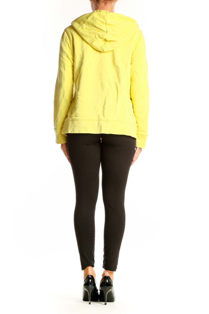 Side view of person wearing yellow Adidas hoodie with black leggings